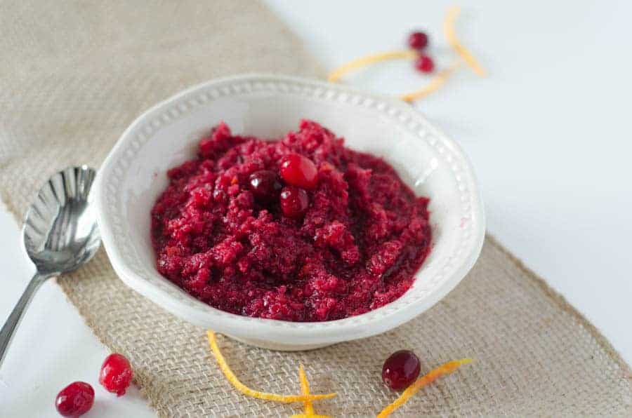 bowl of cranberry orange relish in white bowl on burlap runner