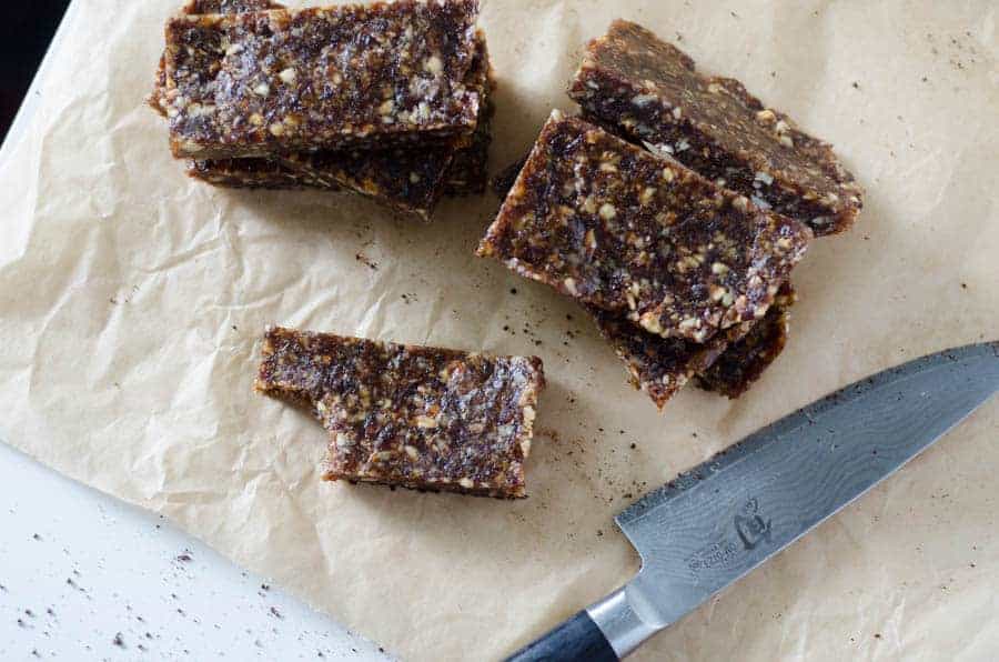 overhead view of date snack bars on butcher paper with knife on the table