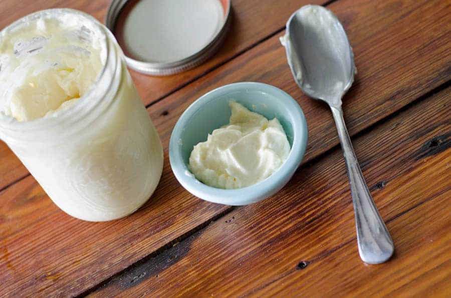 overhead view of an open jar of homemade mayonnaise with a bowl and spoon