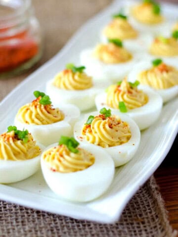 long white plate with deviled eggs spread out on it