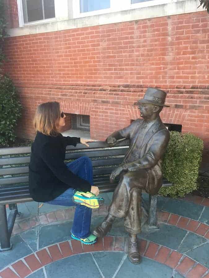 Woman sitting on bench with William Faulkner statue