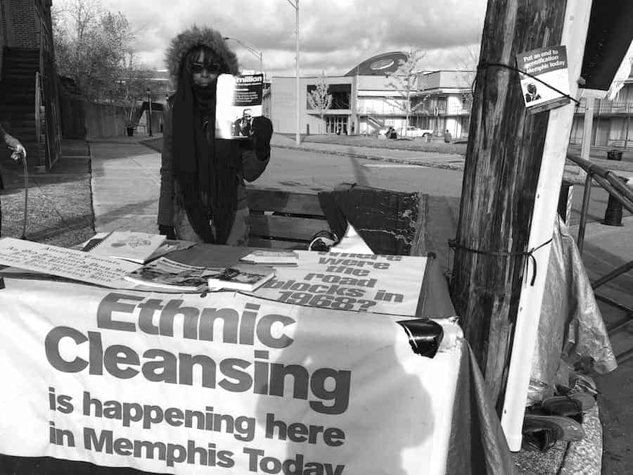 Jacqueline Smith standing behind her table protesting