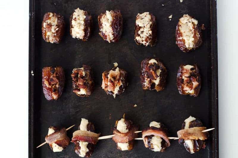 overhead view of a baking sheet with 3 variations of devils on horseback recipe on it