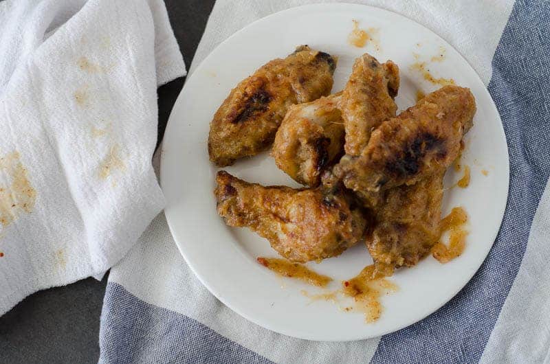 overhead view of messy chicken wings on a white plate