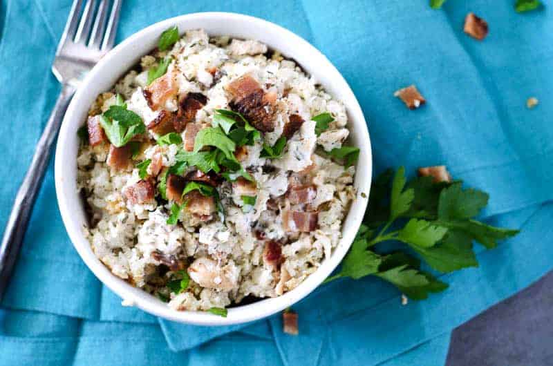 keto chicken bacon ranch casserole in white bowl on a blue napkin with a fork nearby