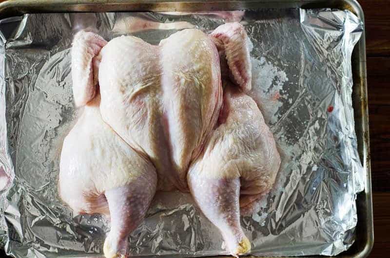 Overhead view of a spatchcocked chicken on a baking sheet