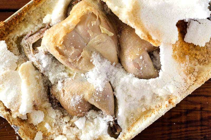 Overhead view of salt crusted chicken after baking with salt crust cracked open