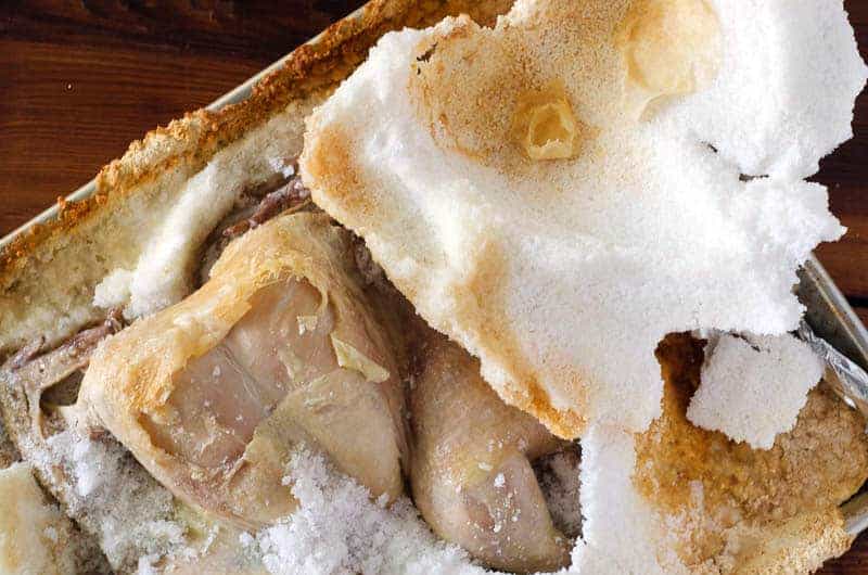 Overhead view of salt crusted chicken after baking with salt crust cracked open