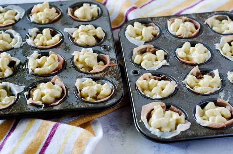 mini muffin tins lined with proscuitto and filled with gluten free mac and cheese