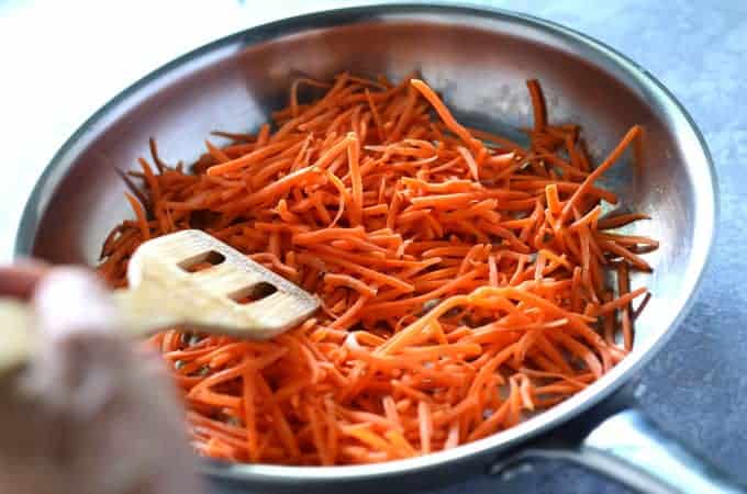 Shredded carrots cooking in pan