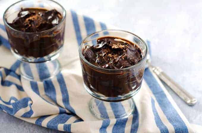 two trifle dishes of chocolate pudding on a blue stripe towel