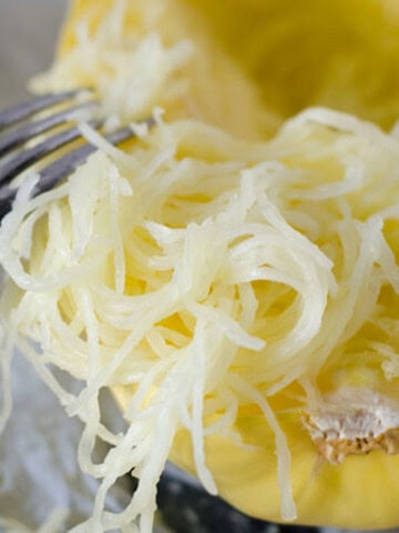 spaghetti squash being shredded with a fork
