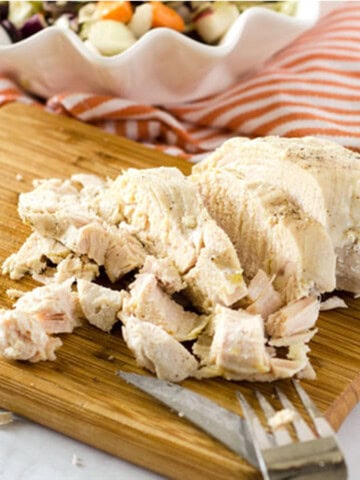 chicken breasts cooked in the instant pot shredded on a wooden cutting board