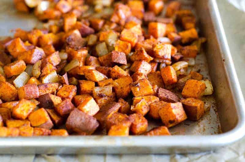 Close up view of roasted sweet potato cubes on a baking sheet