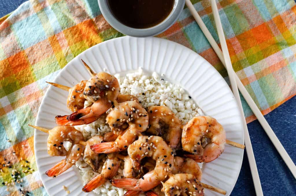 Overhead view of Traeger grilled shrimp on a plate topped with sesame seeds