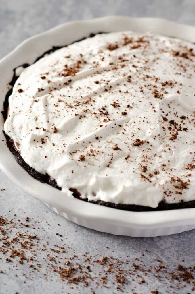 Dairy free and gluten free chocolate peanut butter pie in a pie pan topped with chocolate shavings