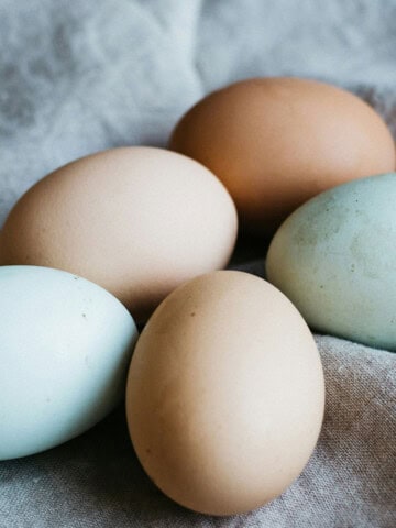 A mix of colored farm eggs on a soft cloth