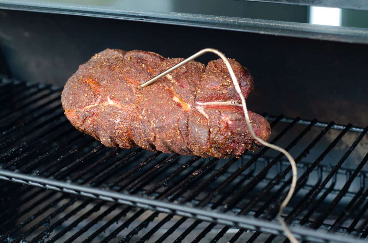 Pork butt on traeger cooking with meat thermometer