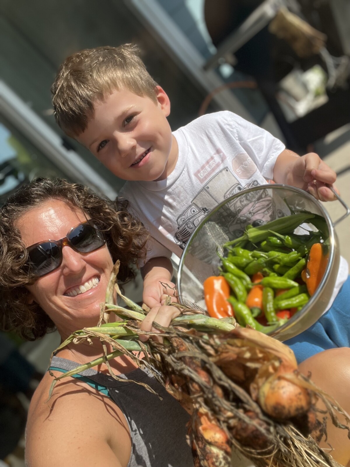 Mom and son showing vegetable garden harvest