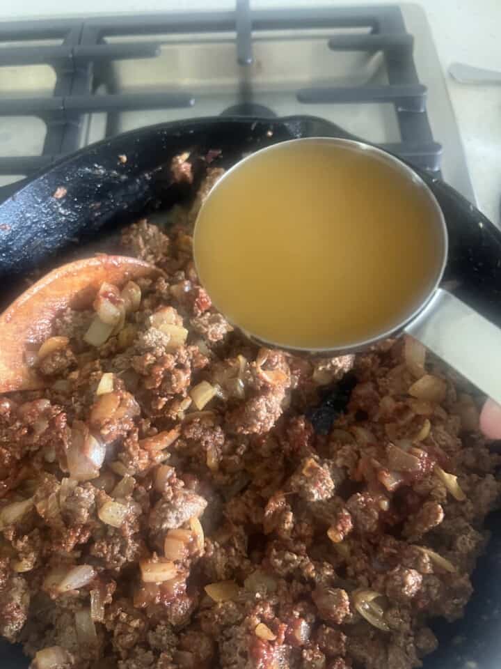 broth added to pan of cooking ground lamb