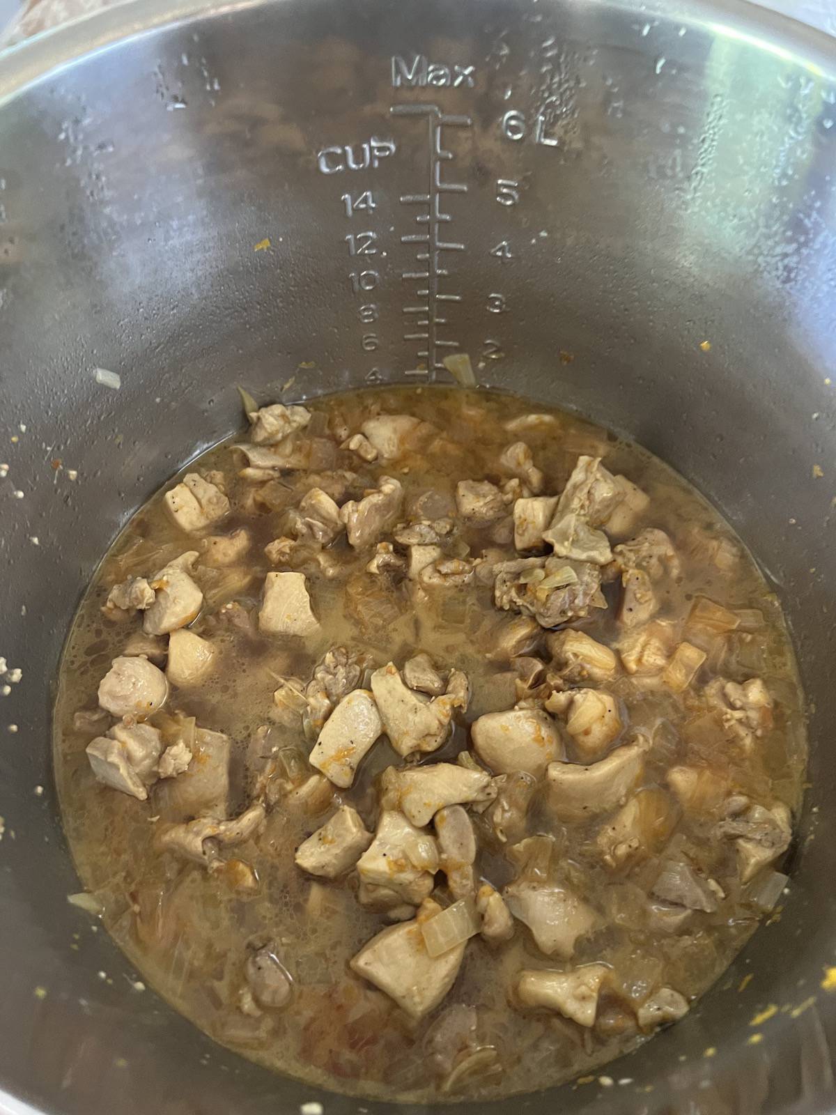 Inside of instant pot with orange chicken cooked inside it