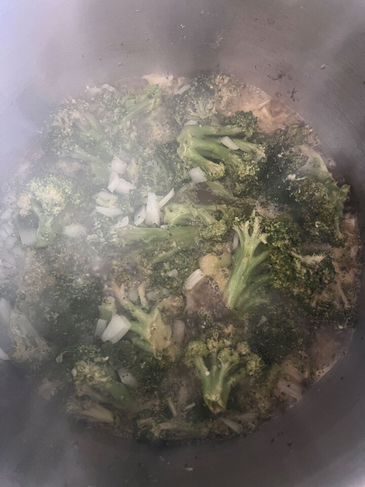 overhead view of broccoli soup ingredients steaming in stockpot