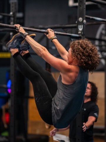 side view of woman at the completion of toes to bar movement