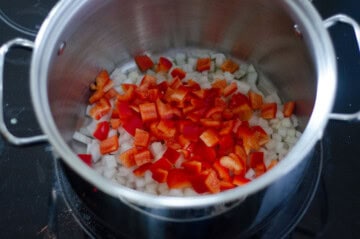 white onion and red bell pepper diced and in the bottom of a large stockpot