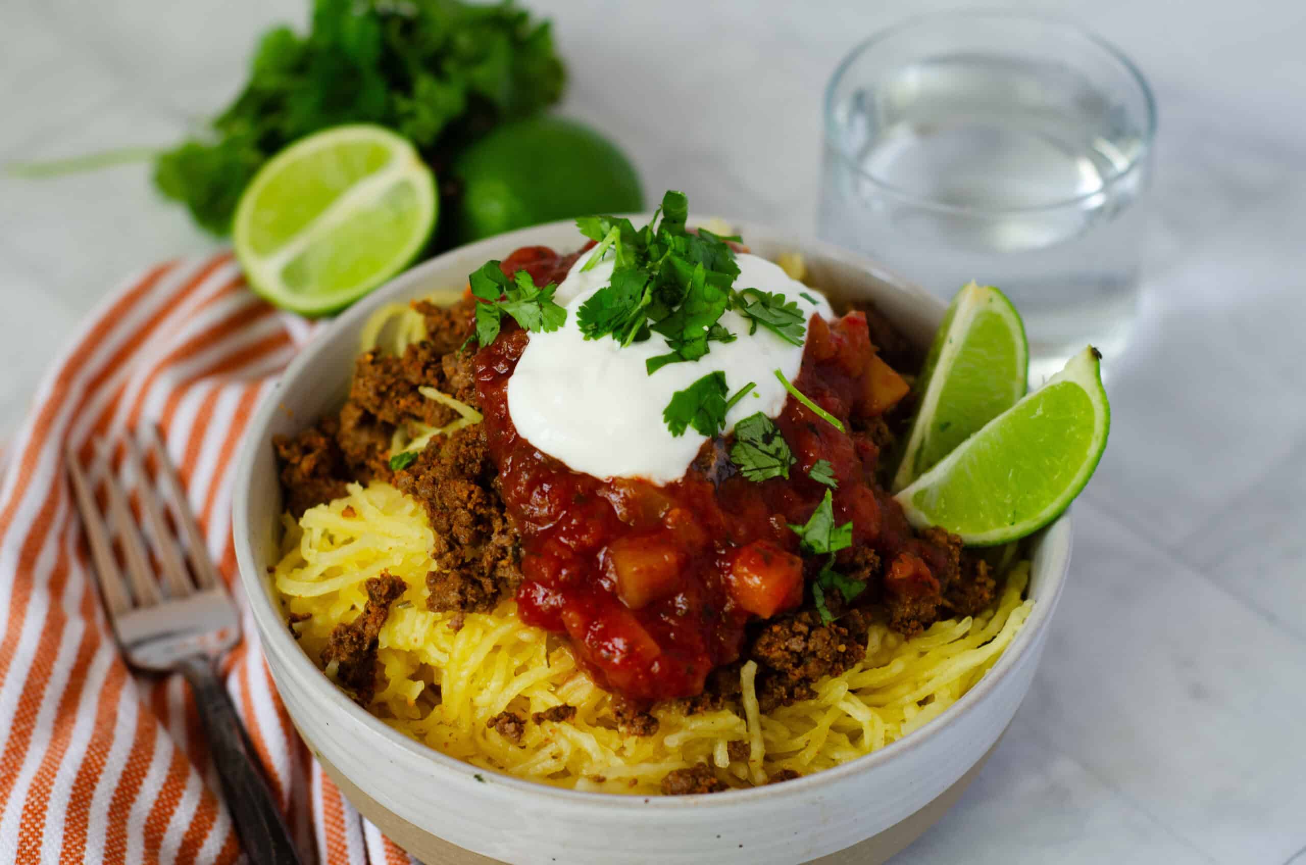 bowl of spaghetti squash with taco meat, salsa, and greek yogurt on top
